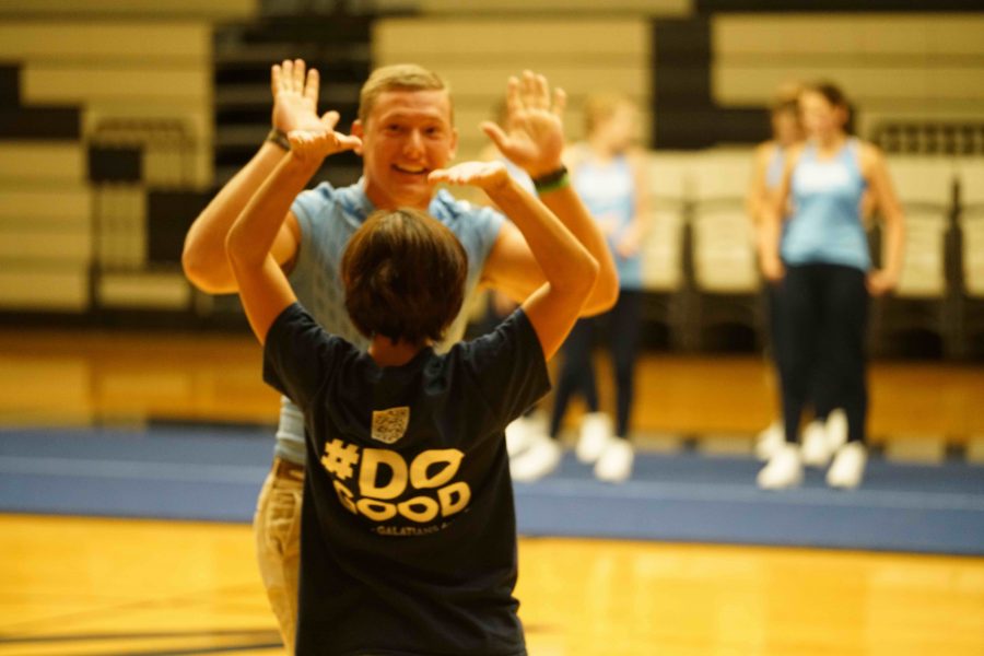 Zach Ronquillo, Senior, and Mrs. Guidry high five each other after winning